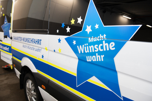 Samariter-Wunschfahrt: Macht Wünsche wahr! Schriftzug auf einem Fahrzeug.