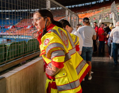 Frau in Samariterbund Uniform schaut auf Fußballplatz