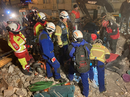 Rettungskräfte arbeiten unter Trümmern nach einem Erdbeben.